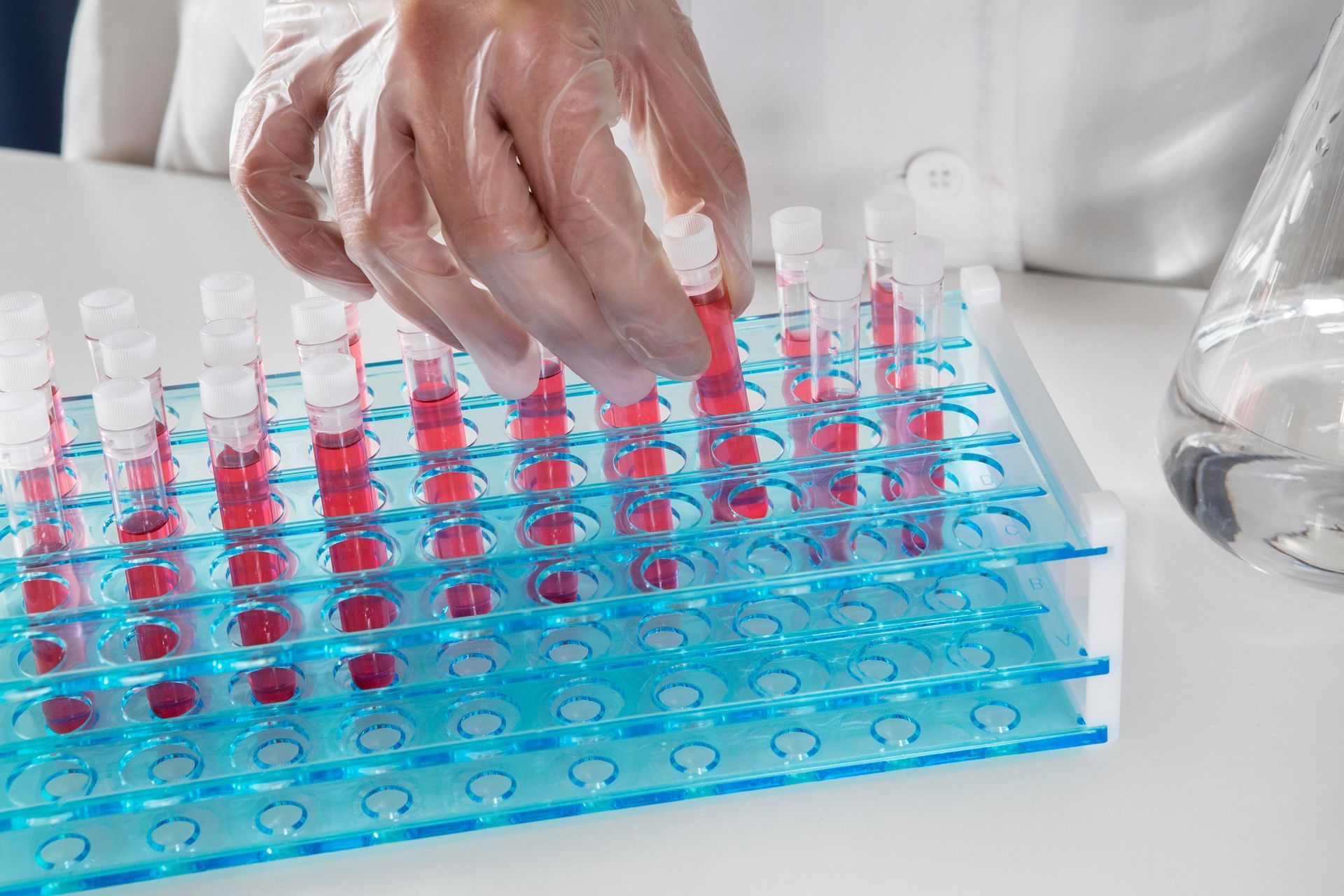 Monitor pharmaceutical temperatures during storage and transport A scientist is pouring a sample into a test tube.