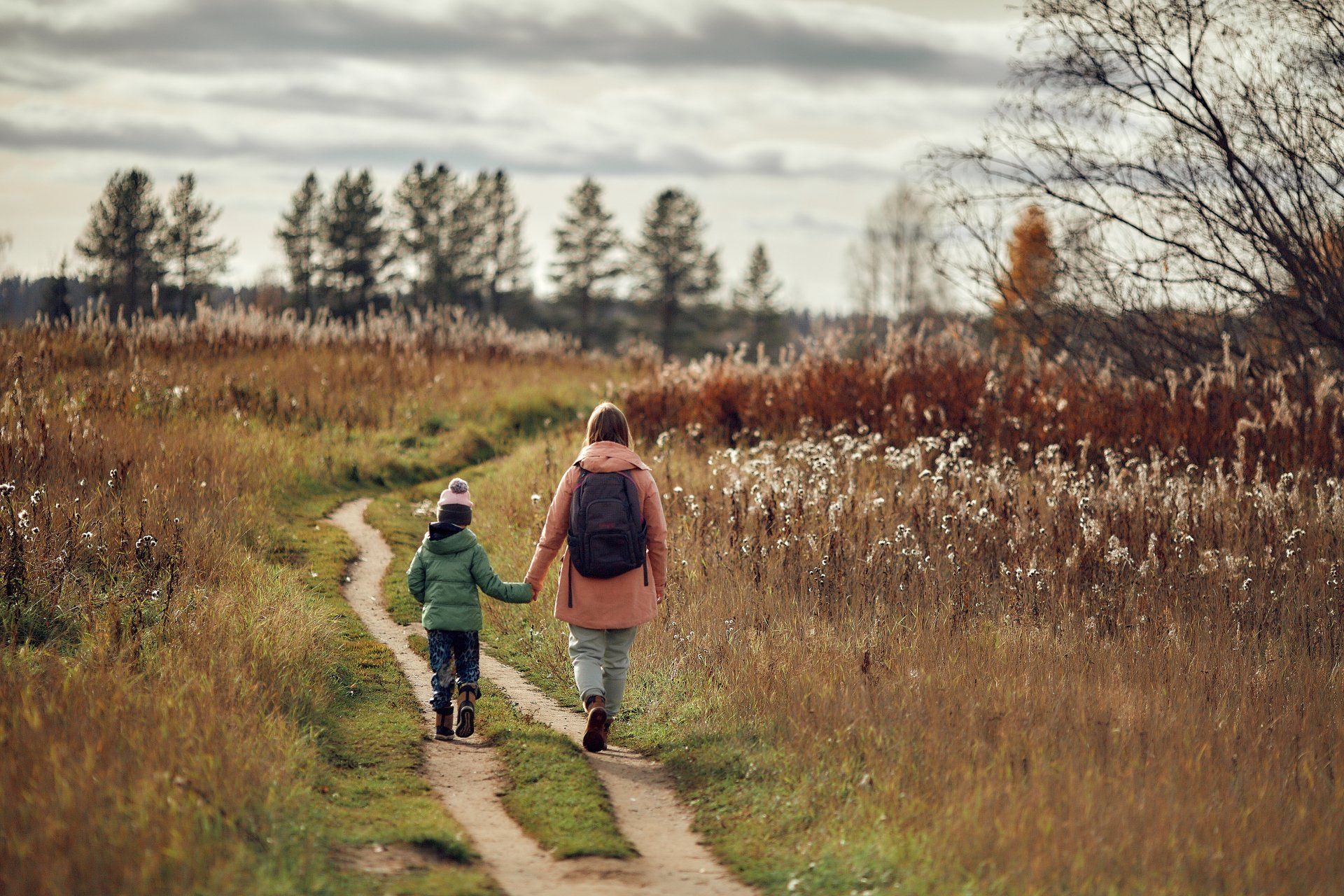A parent walking through nature with their child.