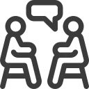 Two stick figures seated and talking, with a speech bubble above one.