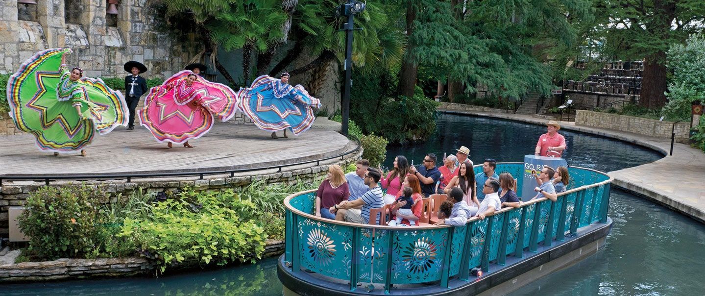 A group of people are riding on a boat down a river.