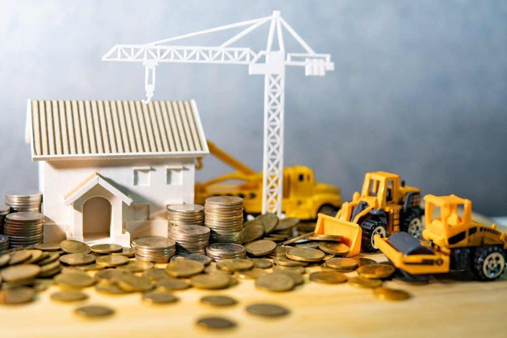 Toy house, construction vehicles, and coins — Freedom Wealth Solutions in Mornington, VIC