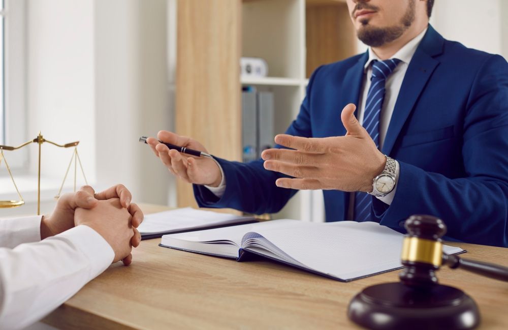 Lawyer in Suit Gestures, Discussing Papers with A Client at A Desk — Freedom Wealth Solutions in Mornington, VIC