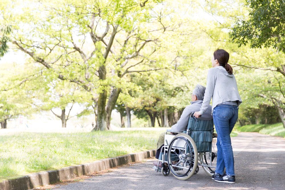 Woman Pushing a Wheelchair With a Person — Freedom Wealth Solutions in Mornington, VIC