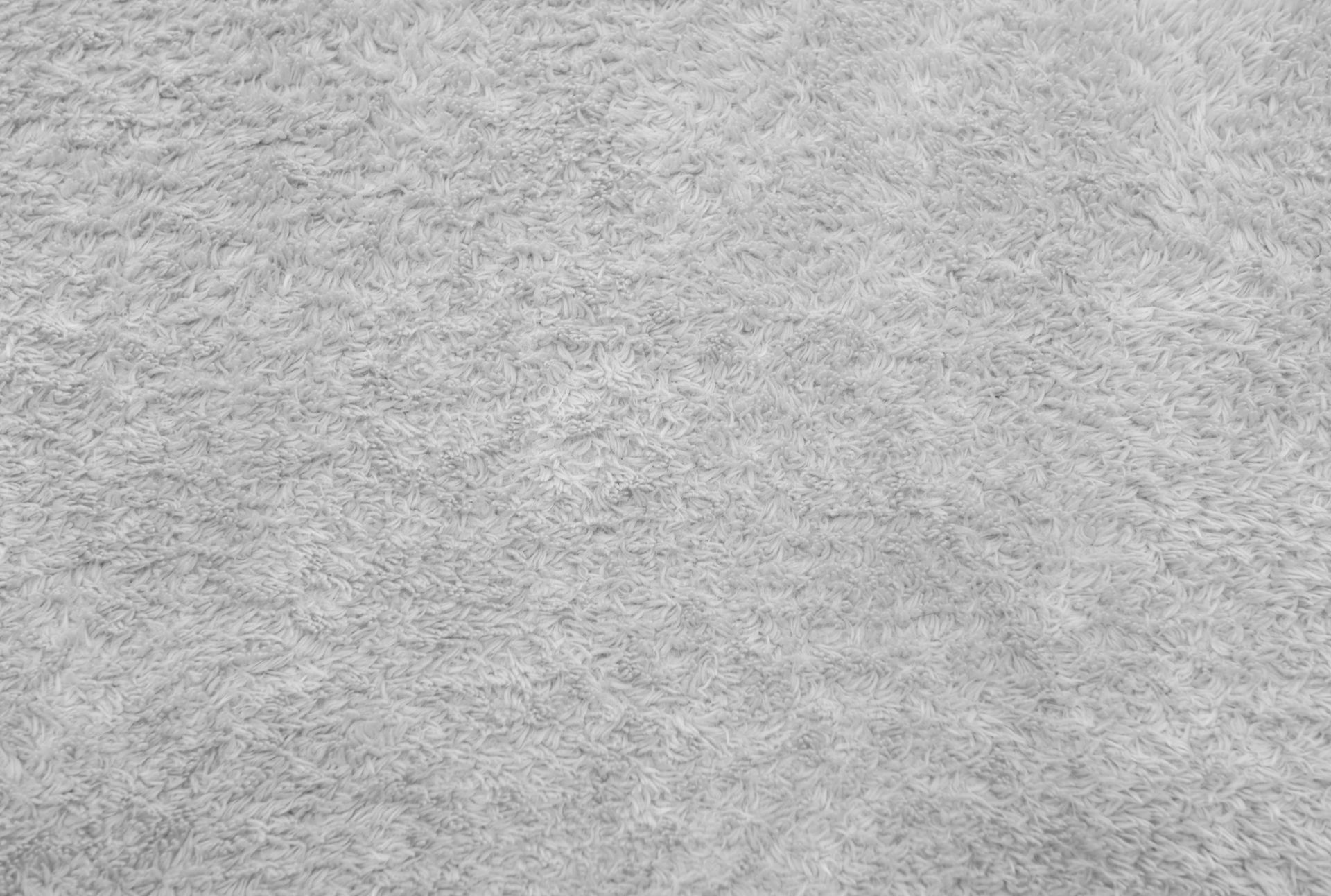 A close-up, high-angle shot of a gray, textured surface with a fuzzy, uneven appearance similar to fabric or felt.