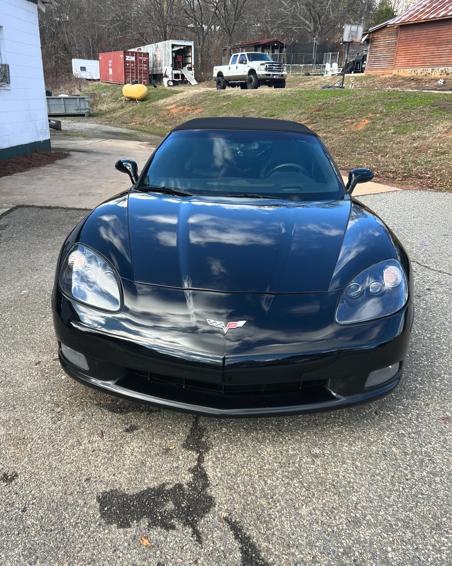 A black sports car is parked in a parking lot.