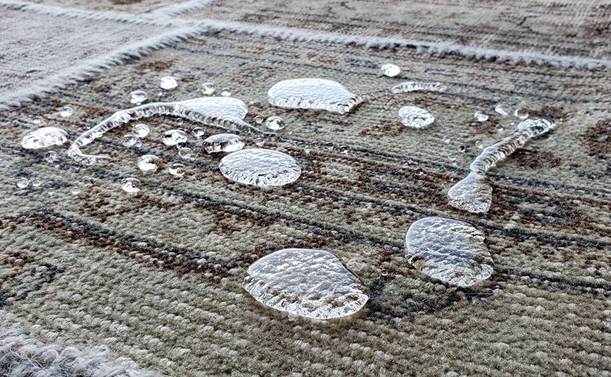 Fresh snow forming a smiley face with eyes on a textured outdoor surface