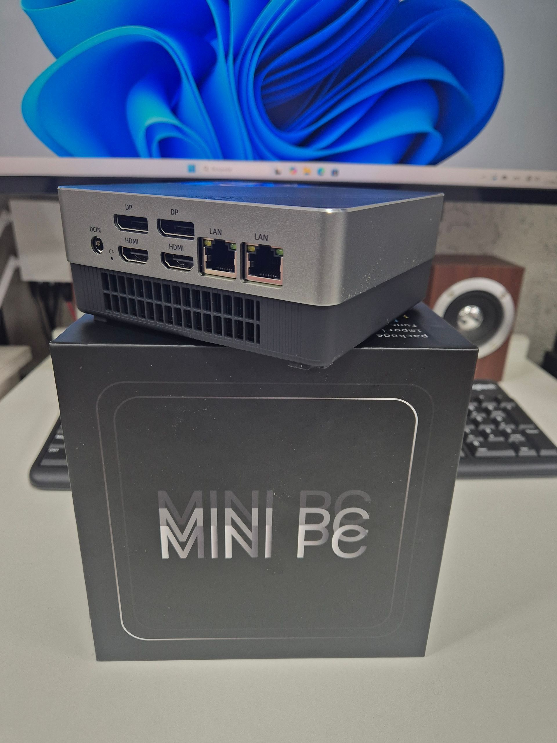 Mini PC plateada sobre una caja negra con la etiqueta