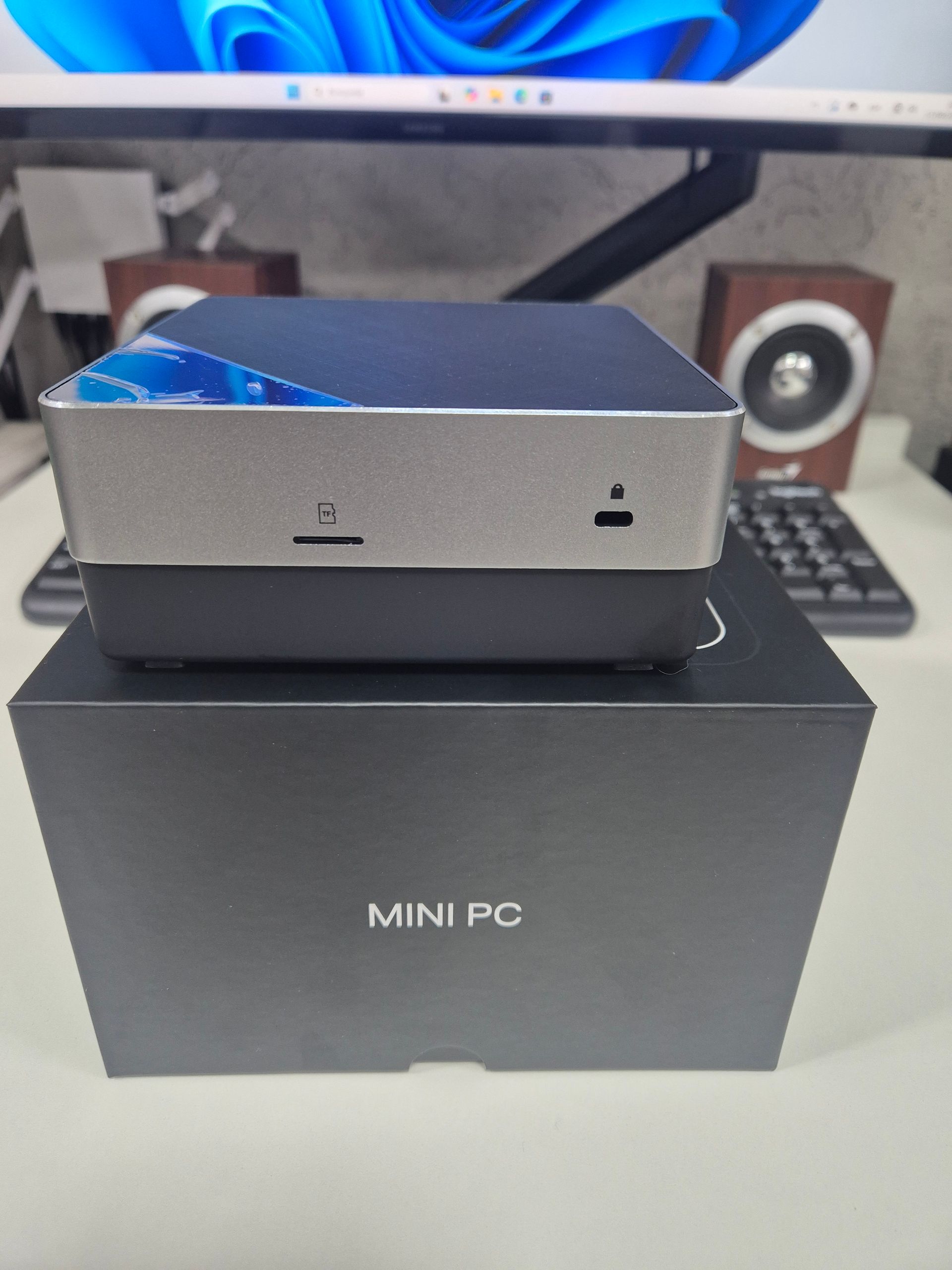 Mini PC plateada sobre una caja negra con la etiqueta