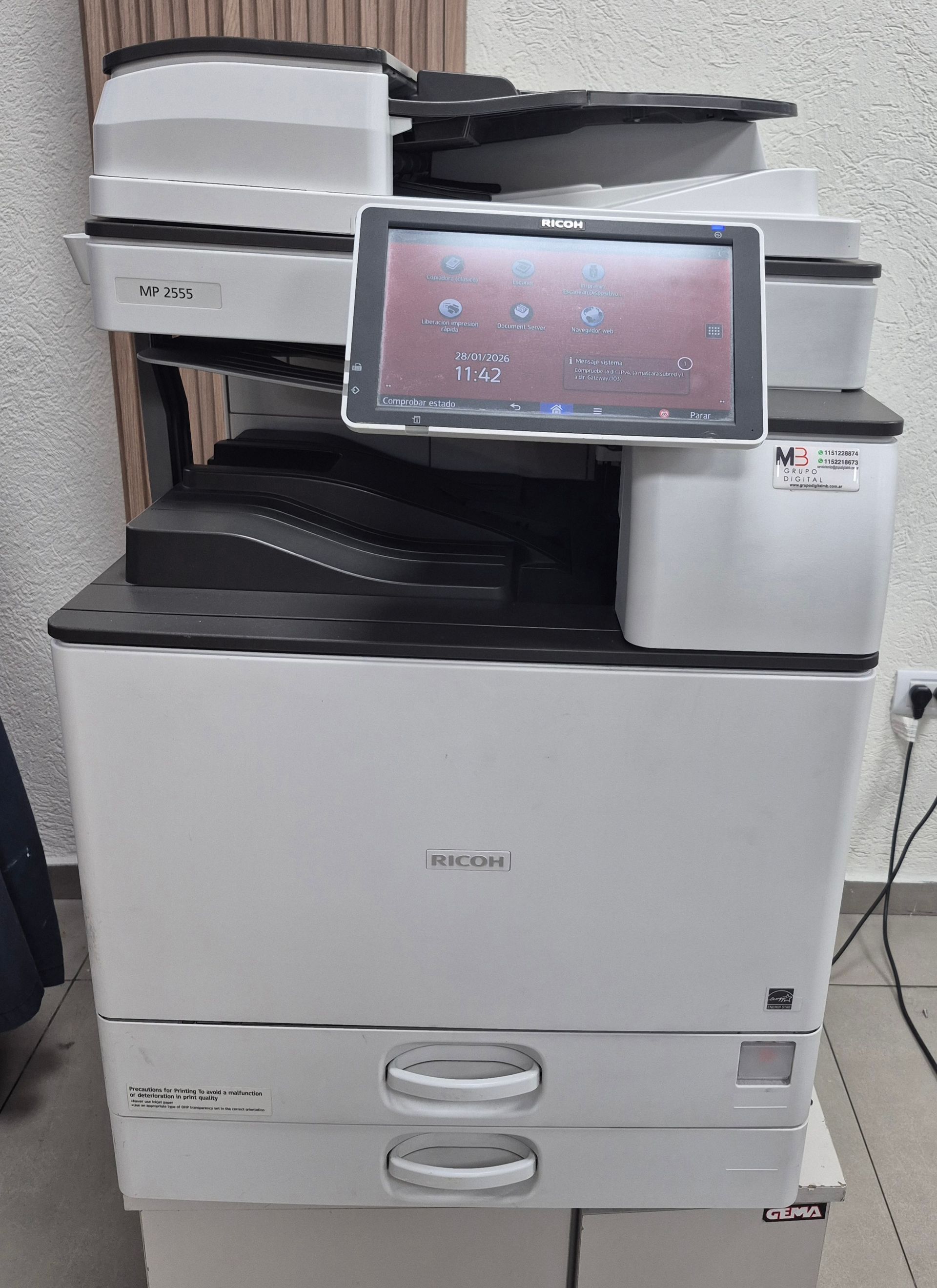Impresora multifunción de oficina con panel táctil y bandejas de papel.