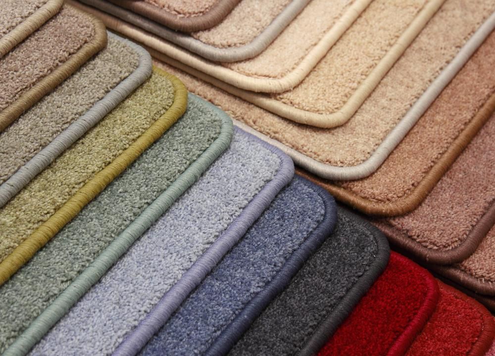 A Bunch of Different Colored Carpets Are Stacked on Top of Each Other — Great Lakes Carpet Cleaning & Restoration In Wingham, NSW