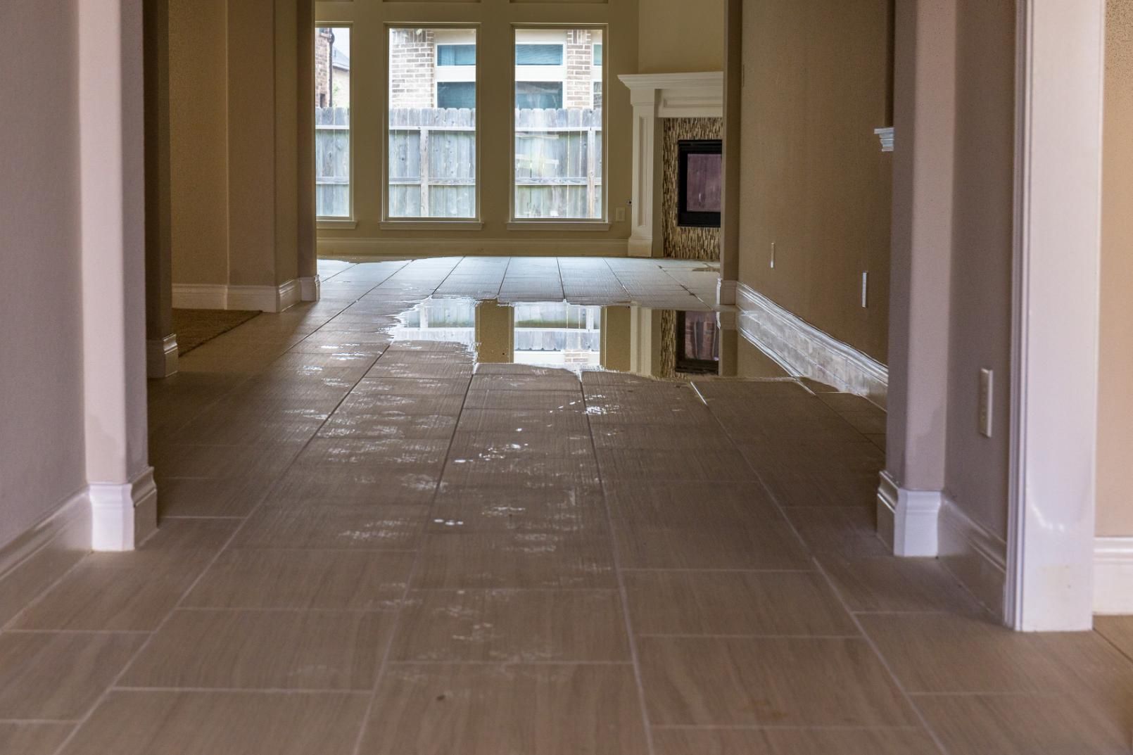 A Flooded Living Room With a Tiled Floor and a Fireplace — Great Lakes Carpet Cleaning & Restoration In Forster, NSW