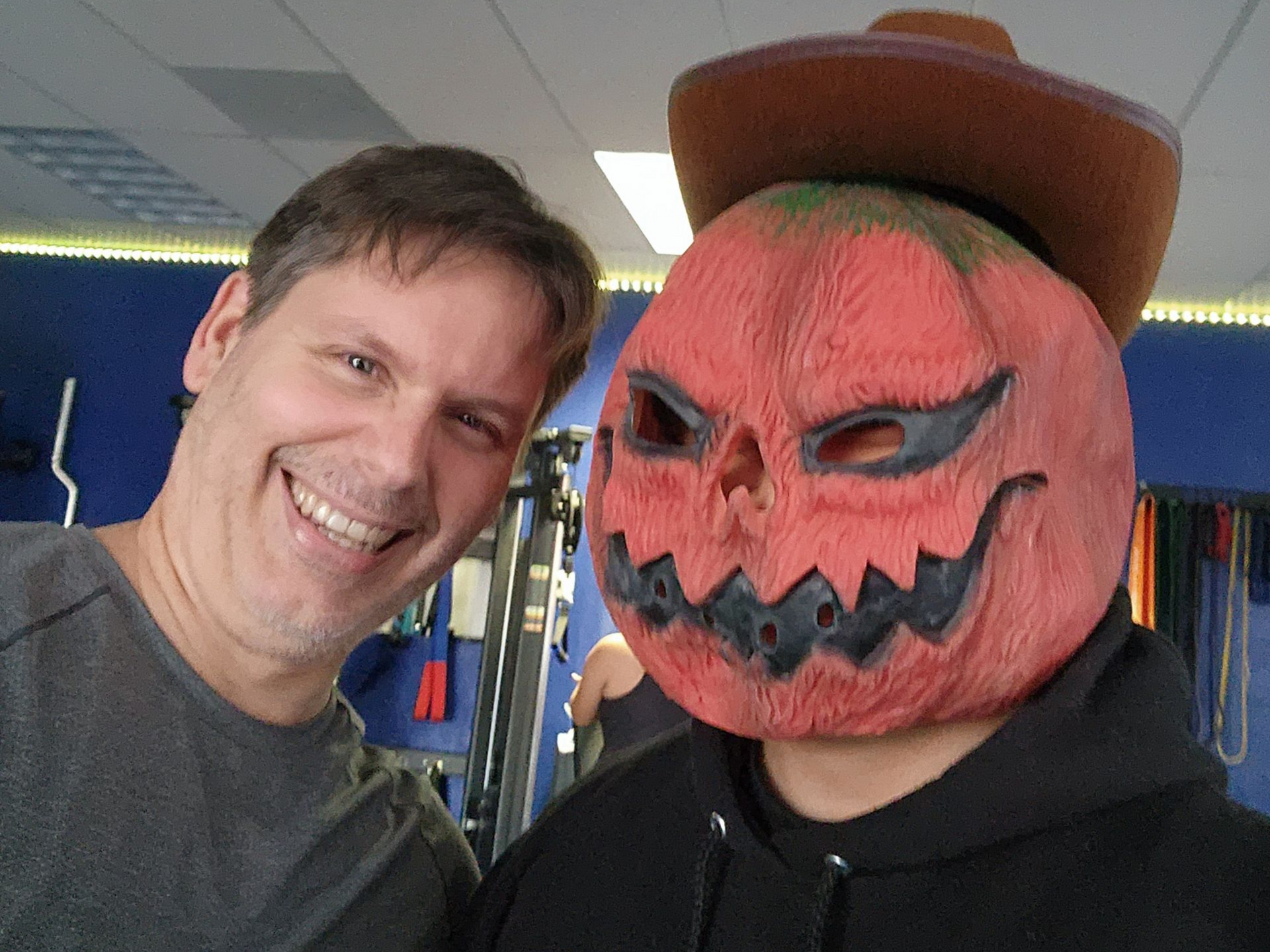 Client smiling with coach in Halloween costume at gym