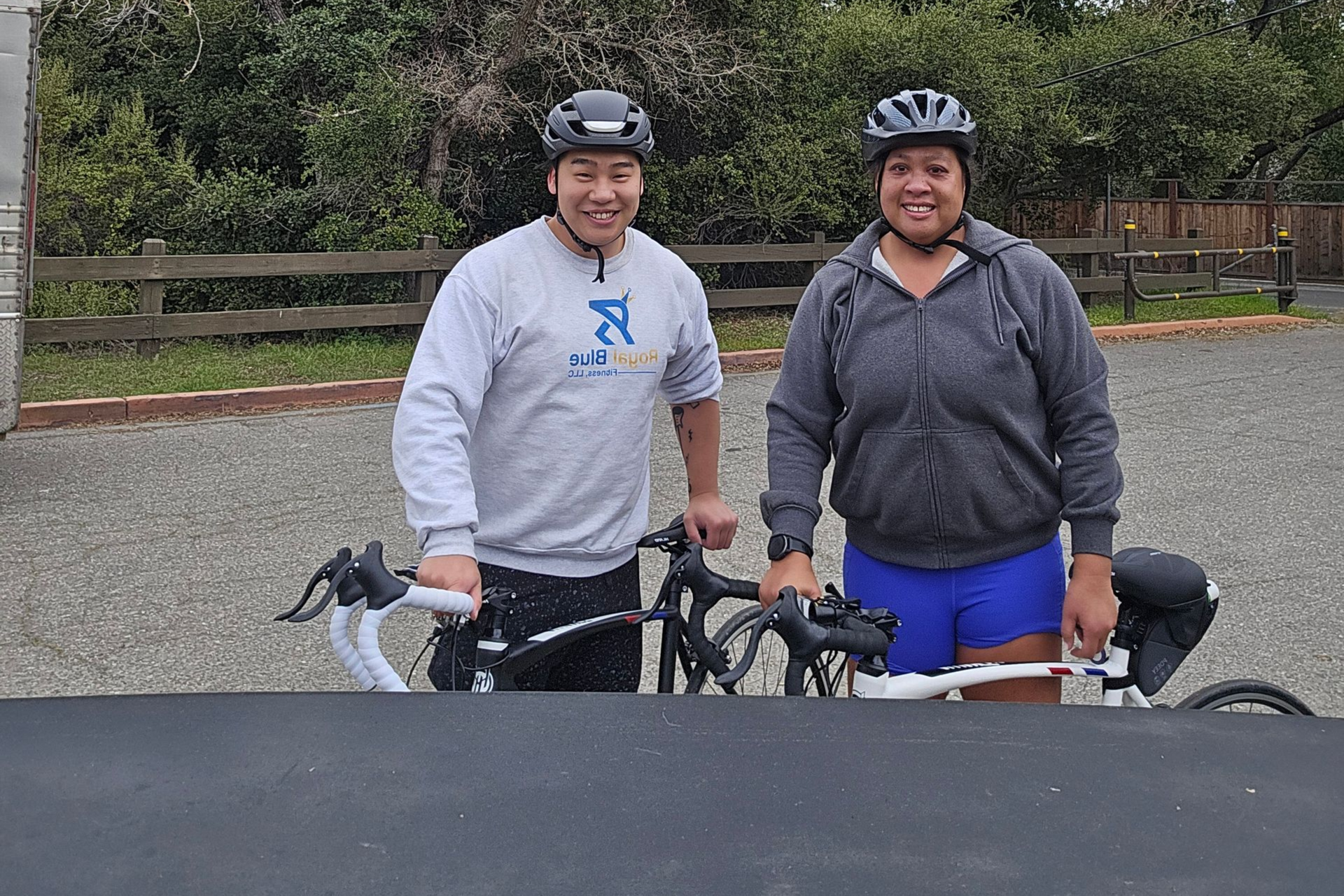 Coach and client smiling with bikes after fitness progress