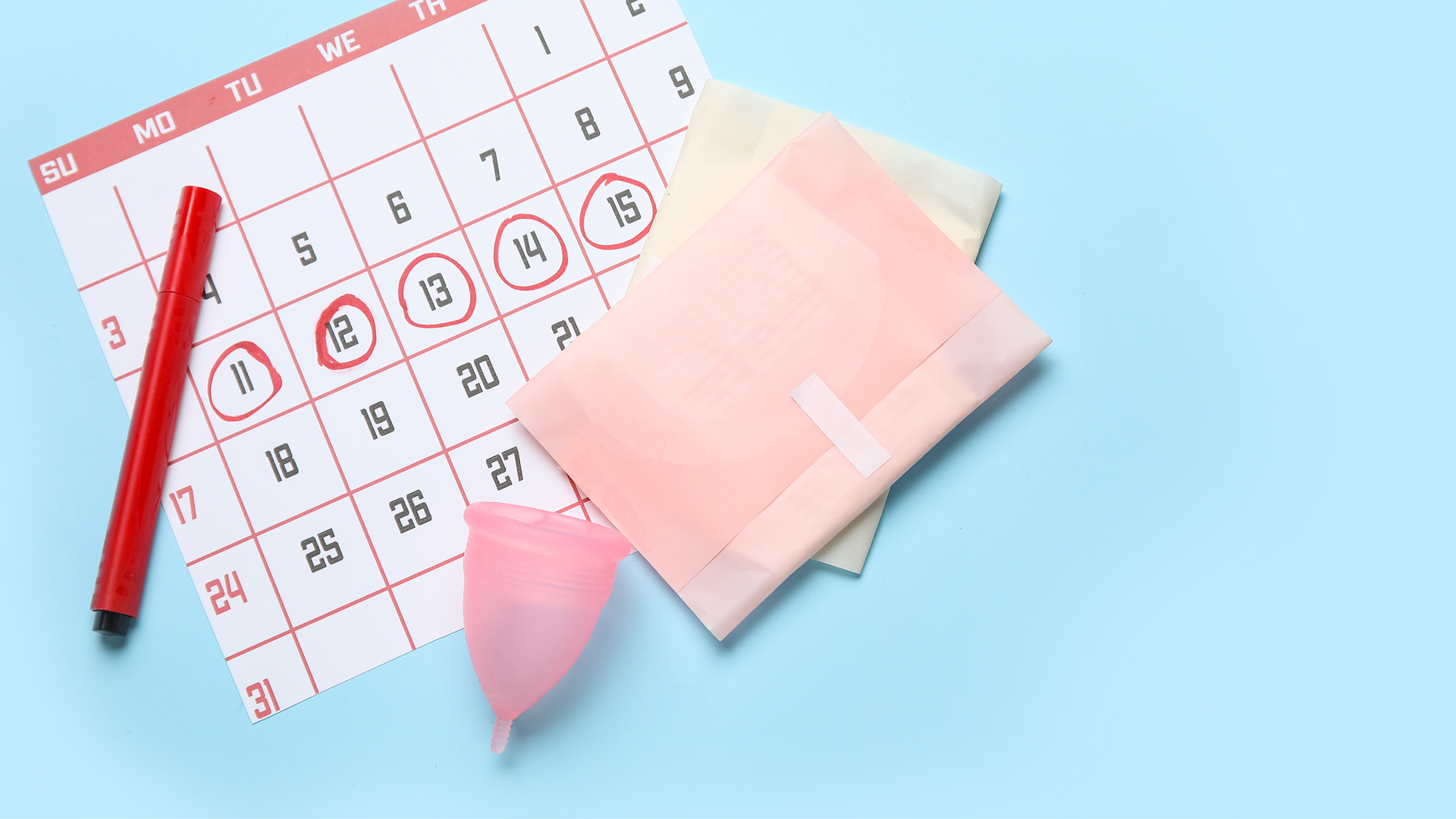 Calendar with circled dates, menstrual cup, and sanitary pads representing menstrual cycle tracking