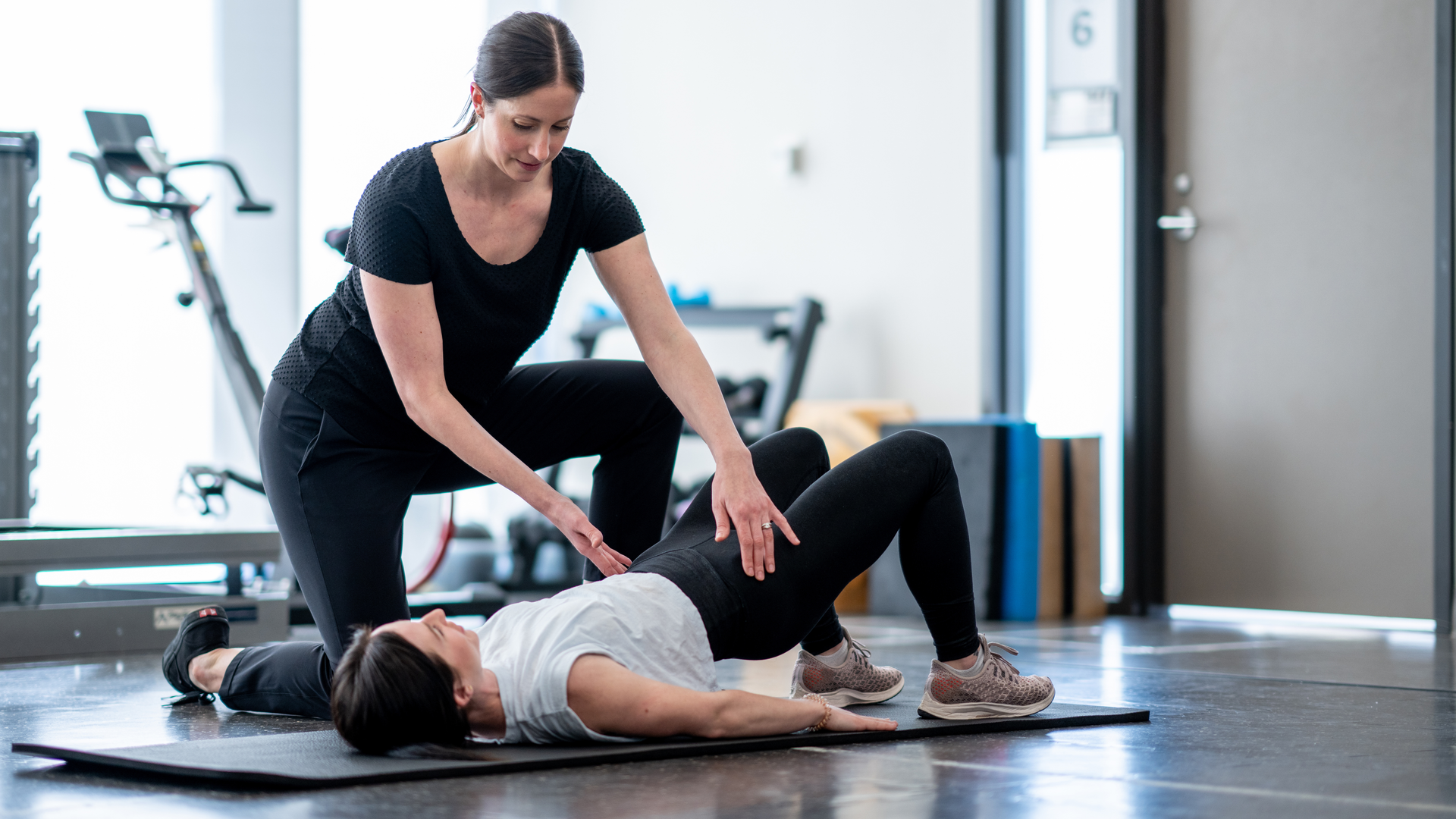 Coach guiding client through pelvic floor strength exercise