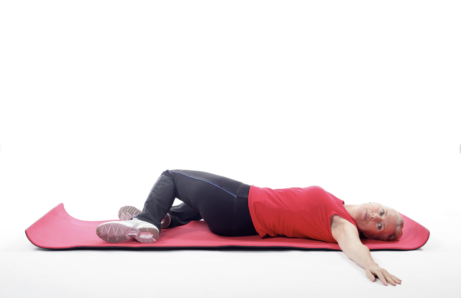 Person lying on mat performing a lower back stretch for sciatica relief