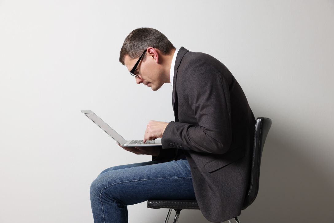 Man hunched over laptop showing poor desk posture