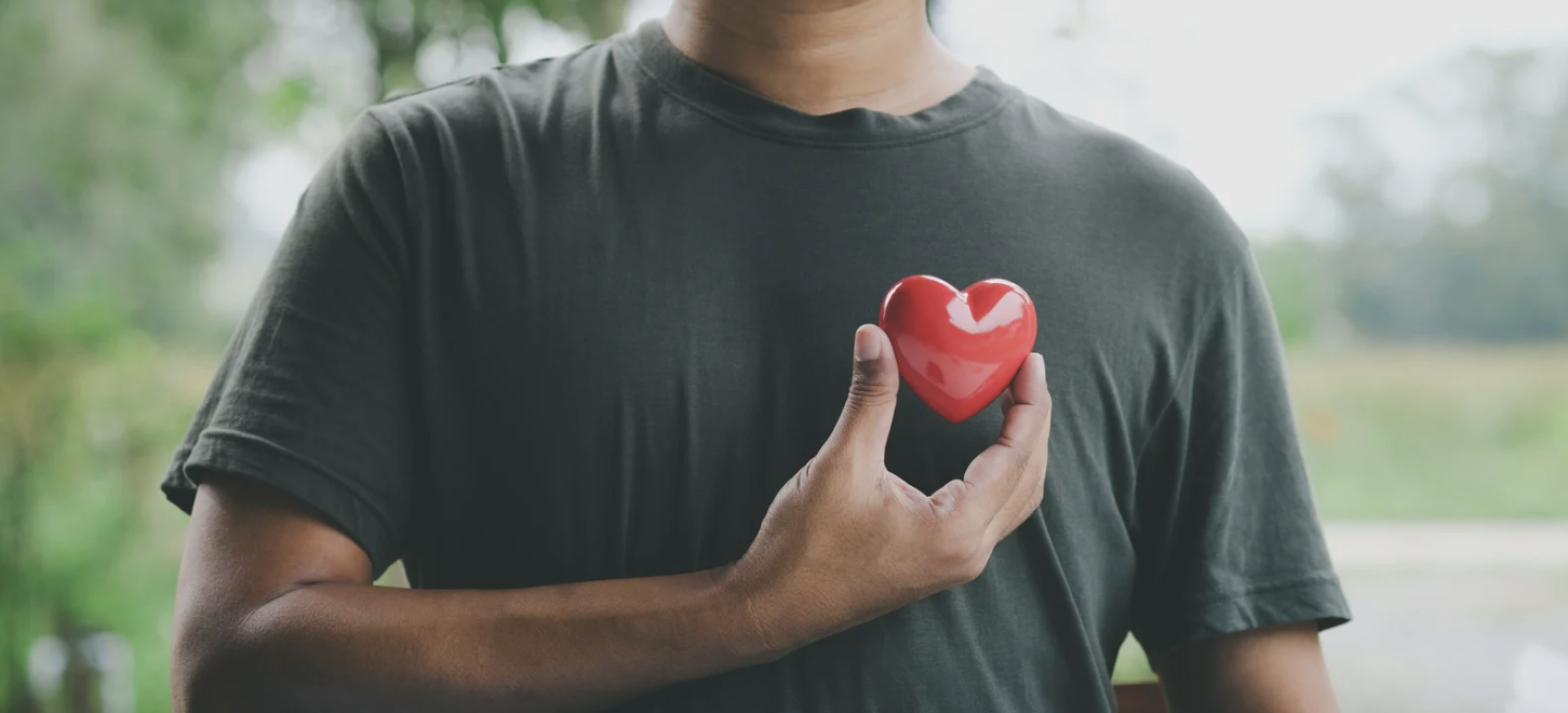 Man holding red heart symbol representing cardiovascular health awareness
