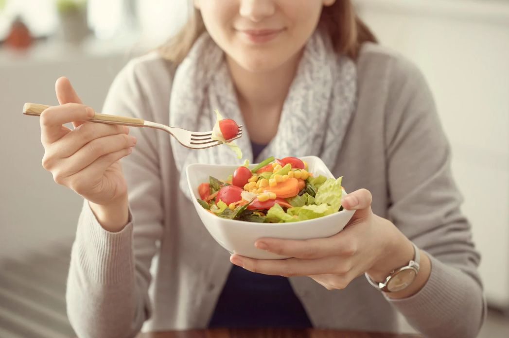 Woman eating a fresh salad for heart health and hypertension management