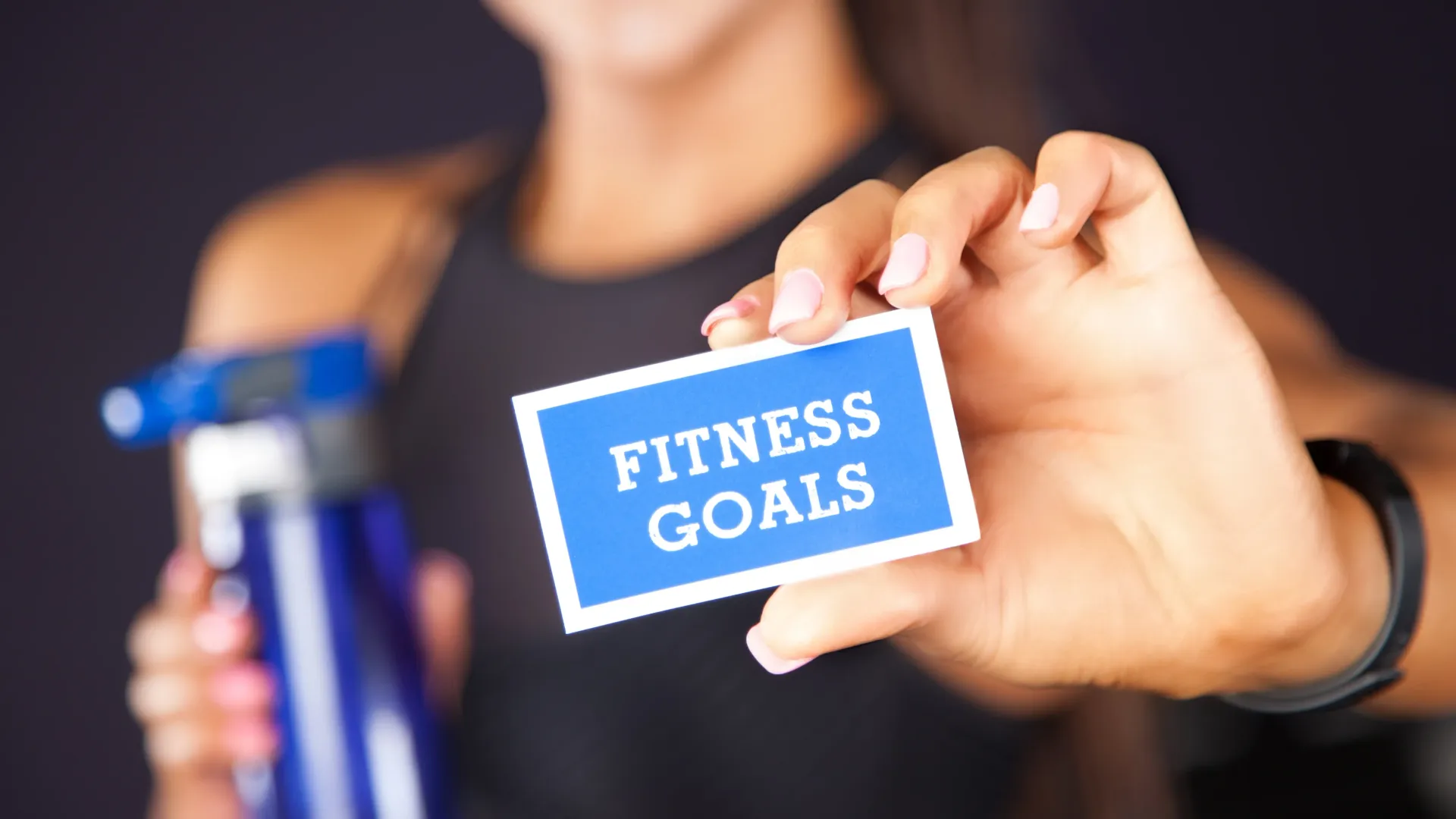 Person writing fitness goals in a planner or journal to build sustainable habits