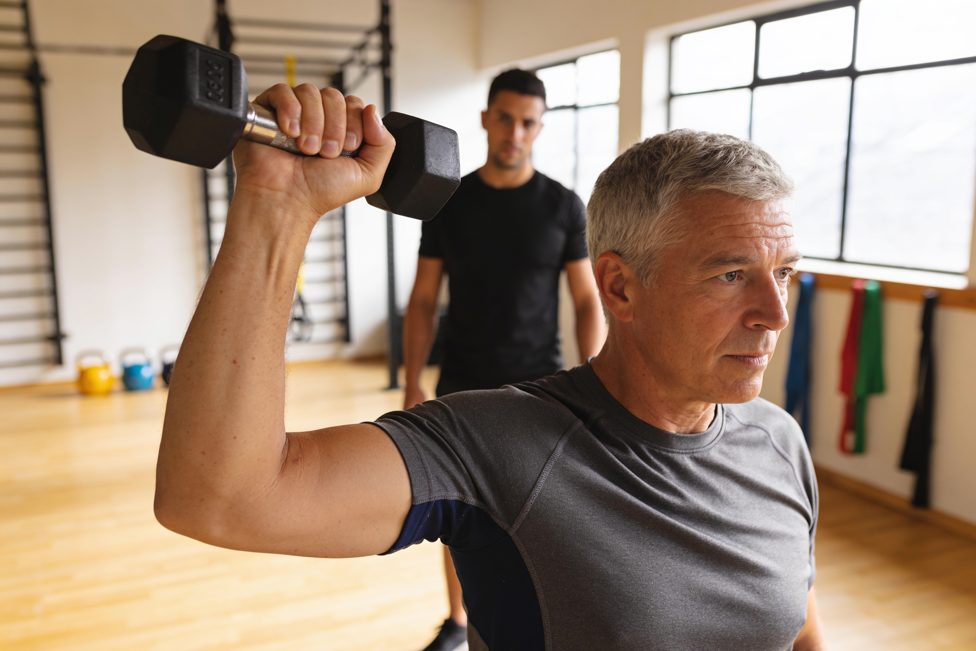 A coach watches closely as a client trains at a sustainable, controlled effort, ready to adjust the