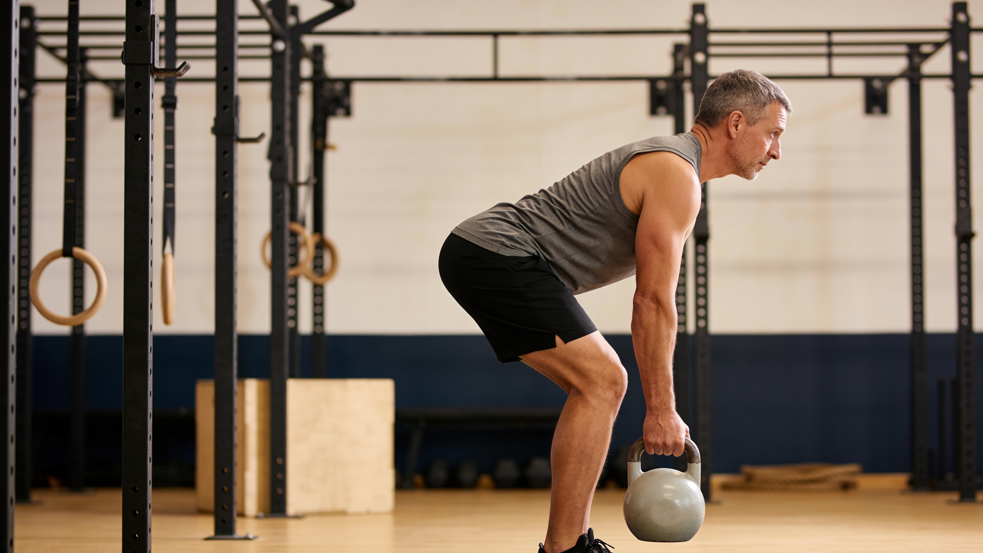 Person performing a controlled hip hinge with a long, flat back.