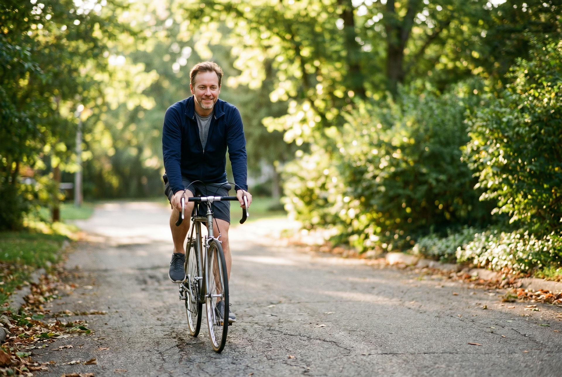 Adult cycling at an easy pace on a neighborhood path, cardio in its supporting role.