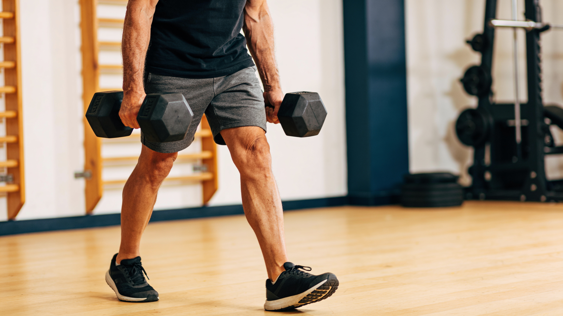 Adult over 50 doing a heavy loaded carry, training grip strength under real load.