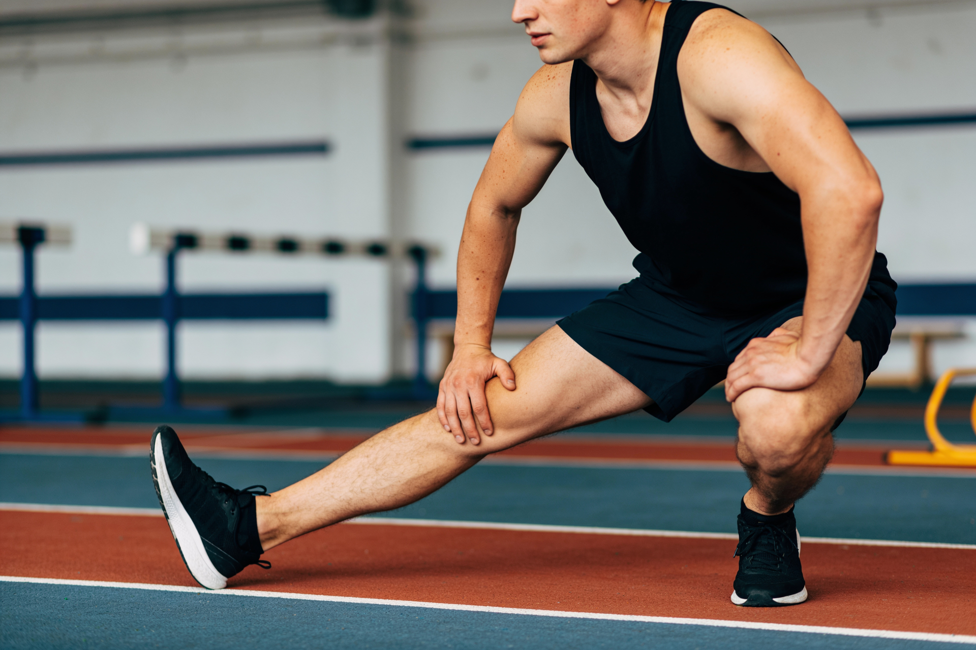 An athlete performing a controlled single-leg pistol squat, demonstrating single-leg ankle and hip control.