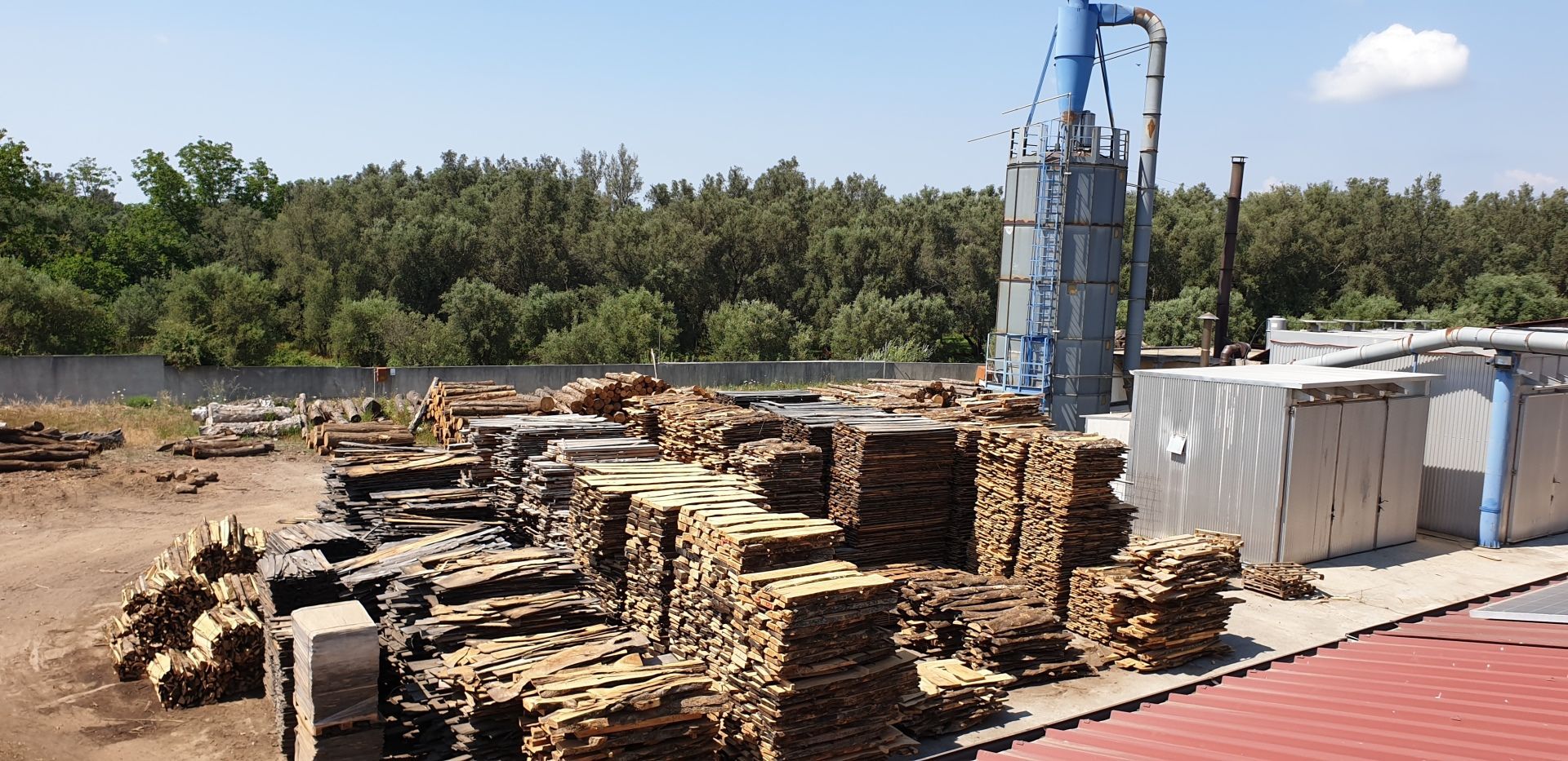 A large stack of wood is placed in front of a building.