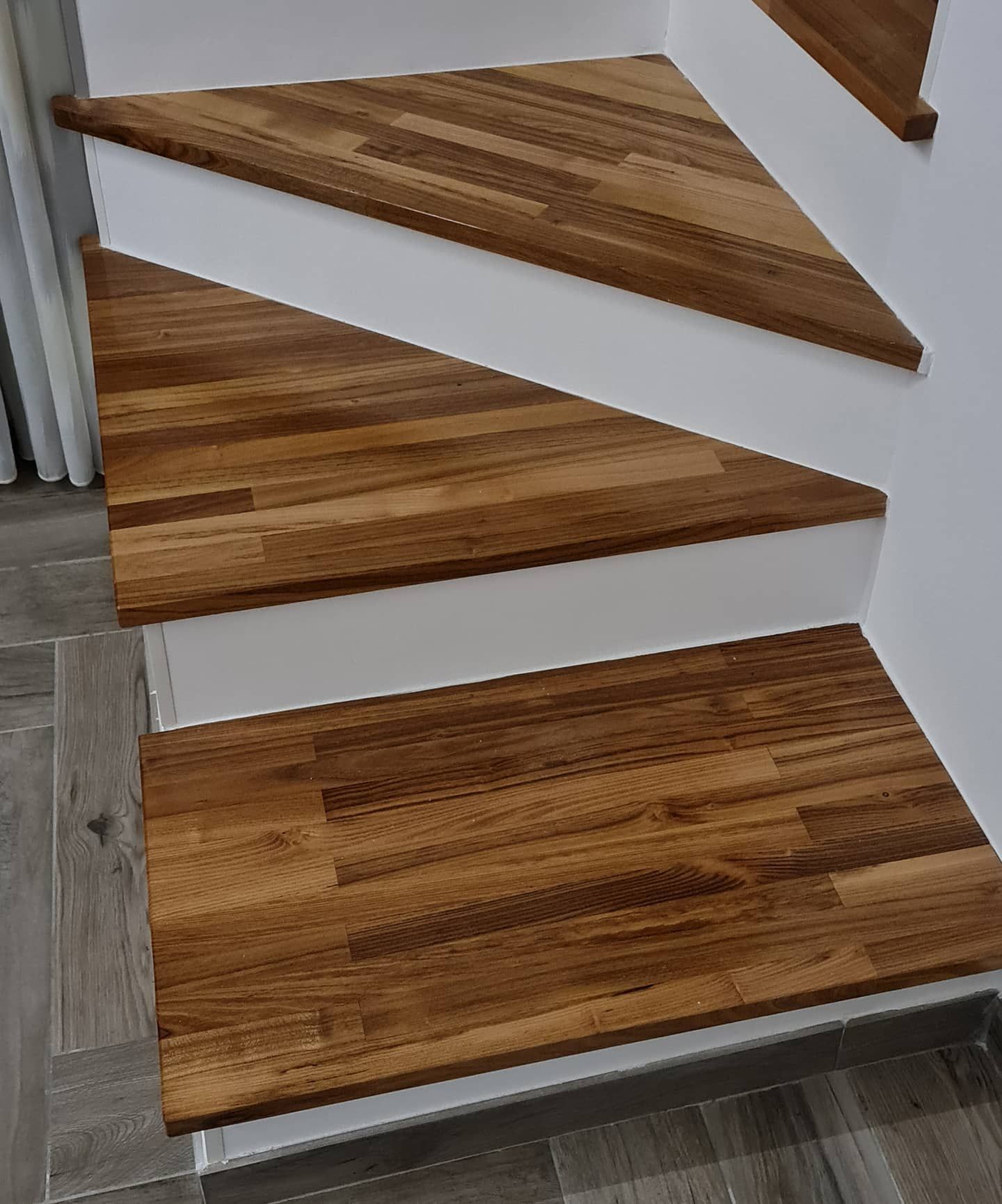Primo piano di una scala in legno con gradini bianchi.