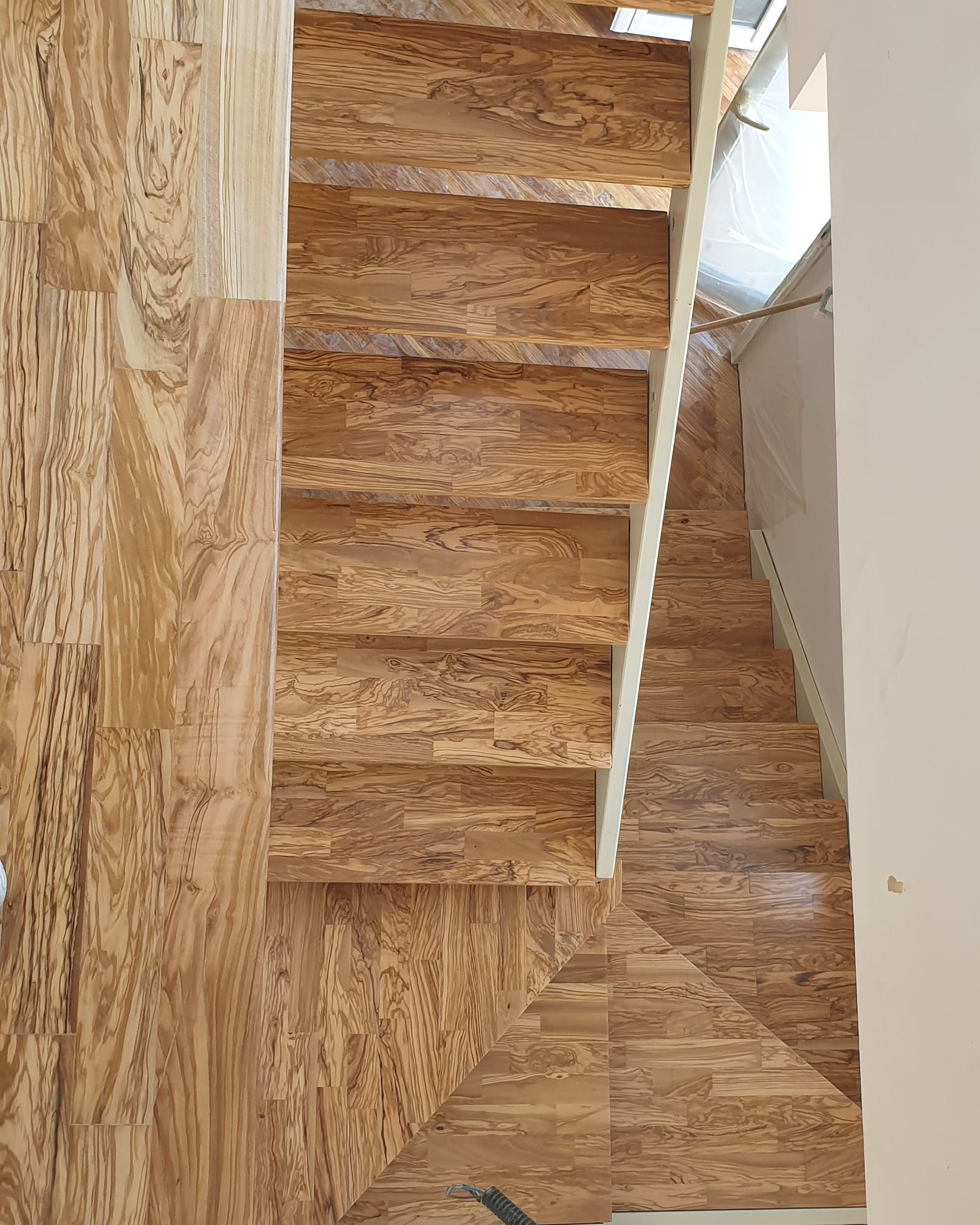 Una scala di legno con una ringhiera bianca in una casa.