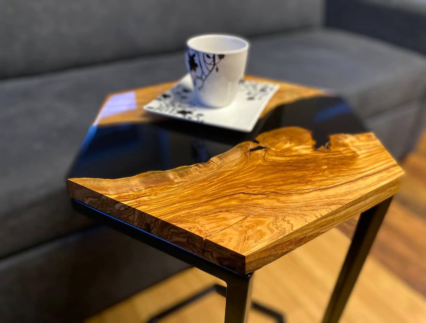 Un tavolo di legno con una tazza di caffè sopra in un soggiorno.