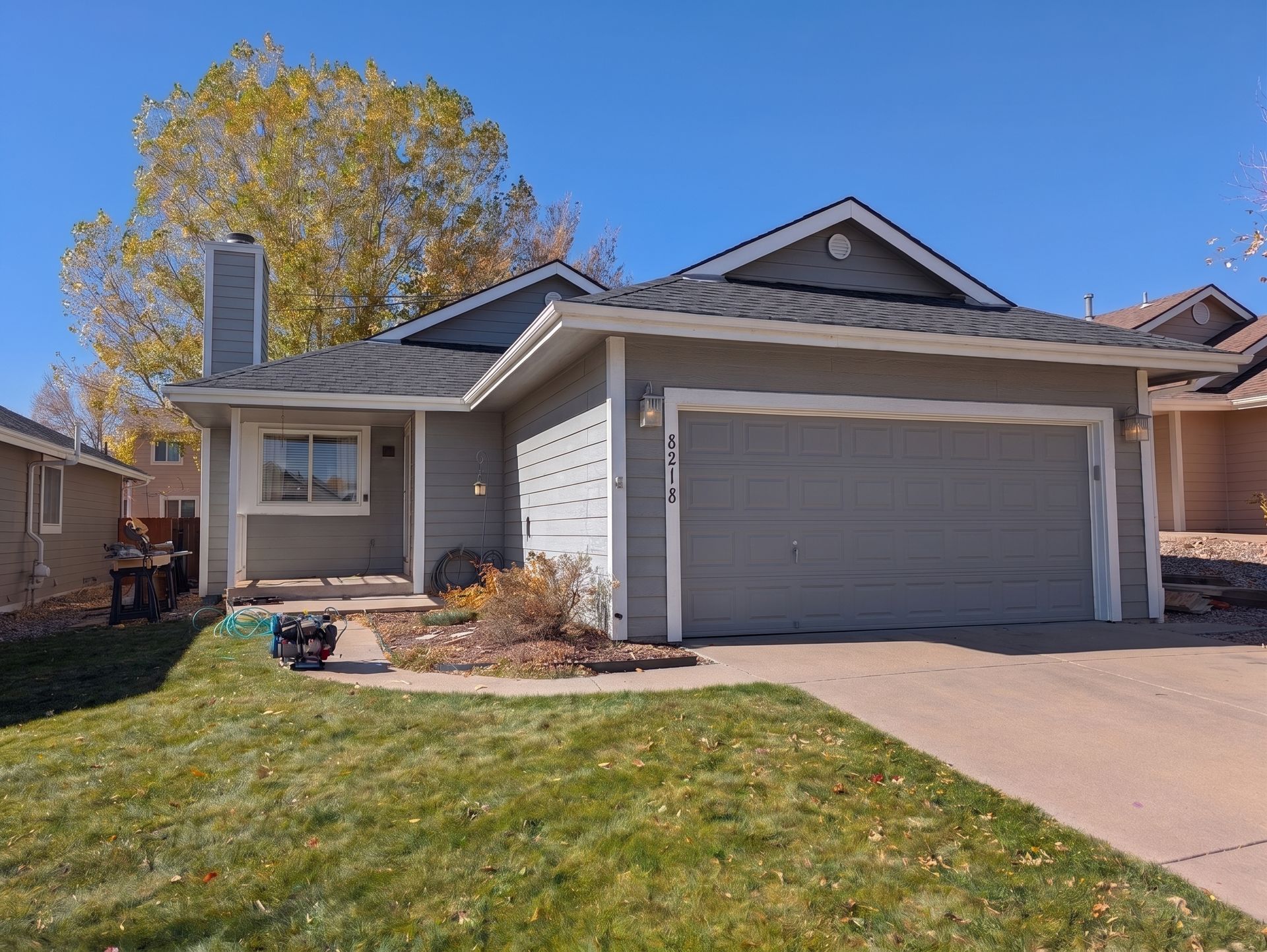 Single-story suburban house with a two-car garage, driveway, and front lawn in daylight