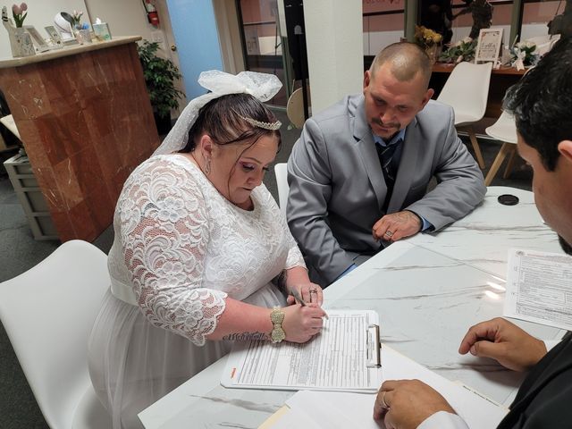 Bride signing a Marriage License as Groom Looks on