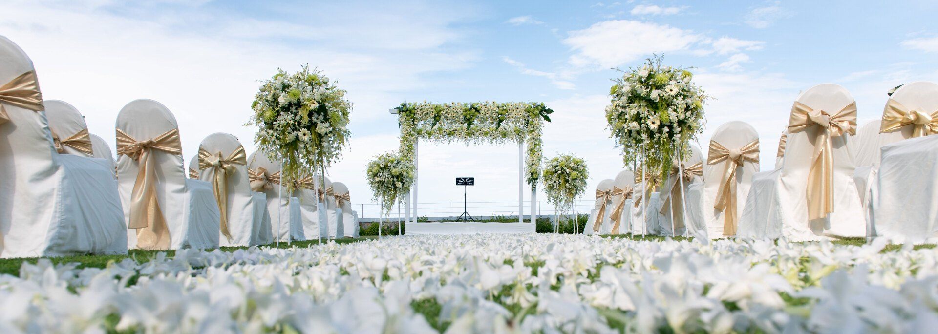 White Arbor and floral decorations as a destinations wedding ceremony venue