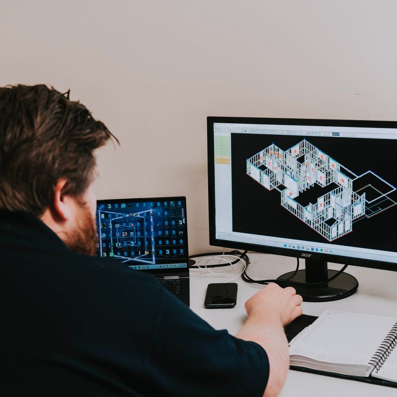 A Man is Sitting at a Desk Looking at a Computer Screen — Steel Frame Company In Orange, NSW