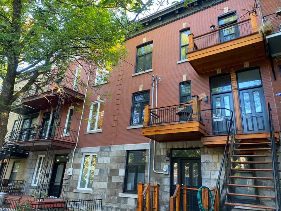 Un grand bâtiment en briques avec des escaliers menant au deuxième étage.