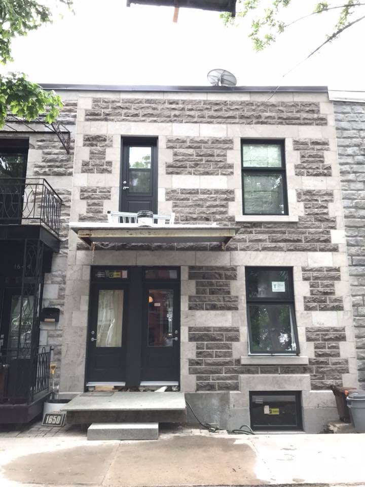 Un bâtiment en briques avec une porte et des fenêtres noires