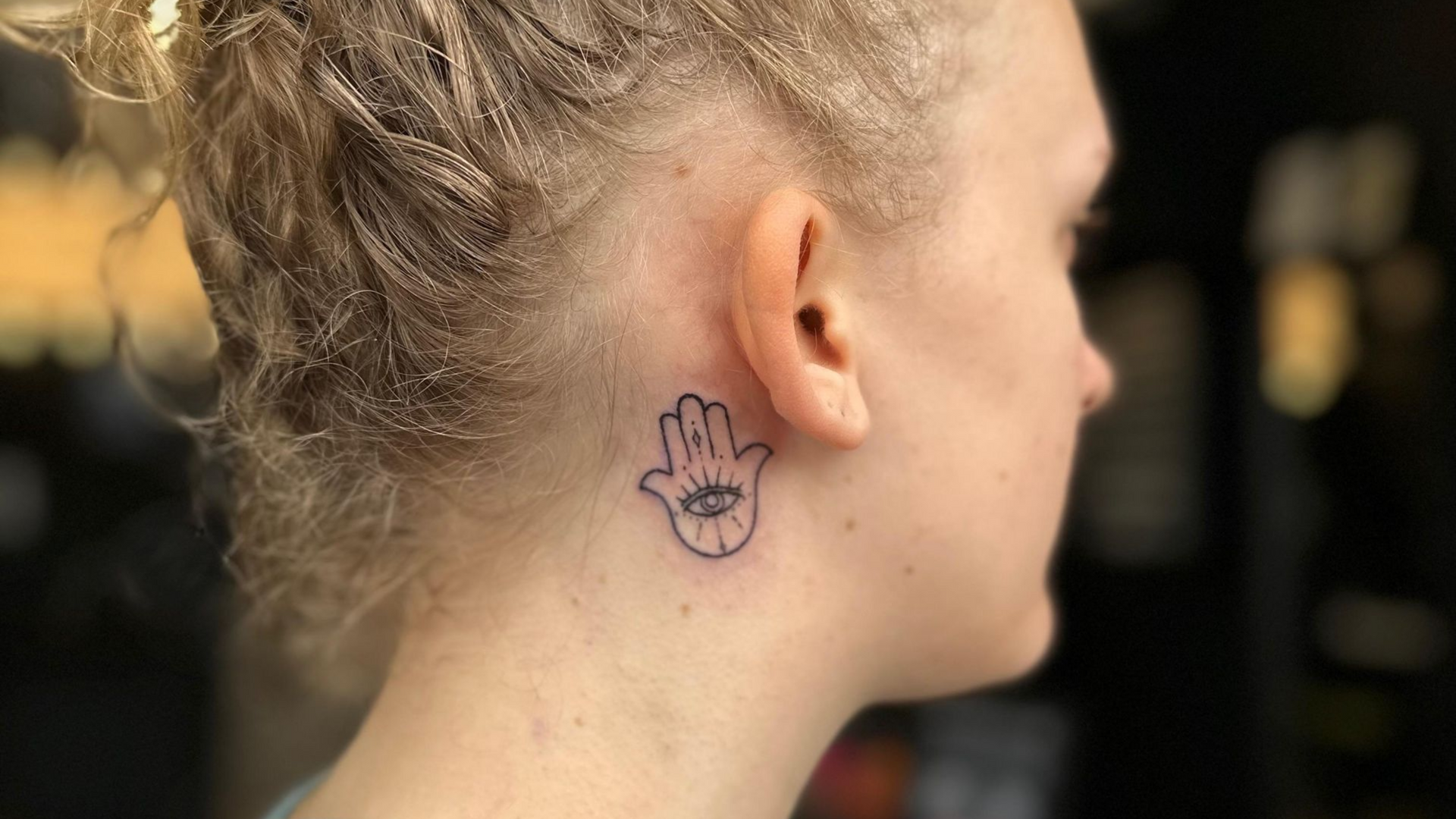 Delicate minimalist tattoo with fine linework and simple geometric shapes on the wrist