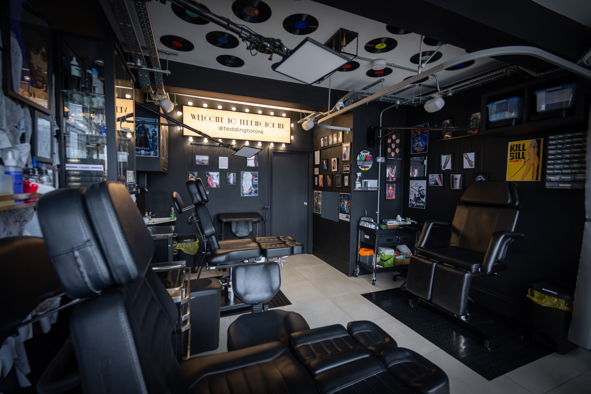 Dark, personalized barbershop interior with black chairs, photo-covered walls, and ceiling decorations