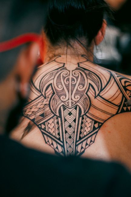 Bold blackwork tattoo with solid black geometric shapes and intricate linework