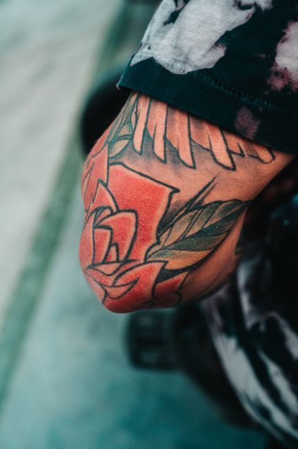 Close-up of a tattooed forearm with a colorful floral and geometric design