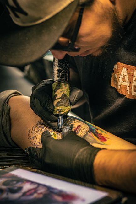 Bold neo-traditional tattoo with rich colours and illustrative linework on an arm