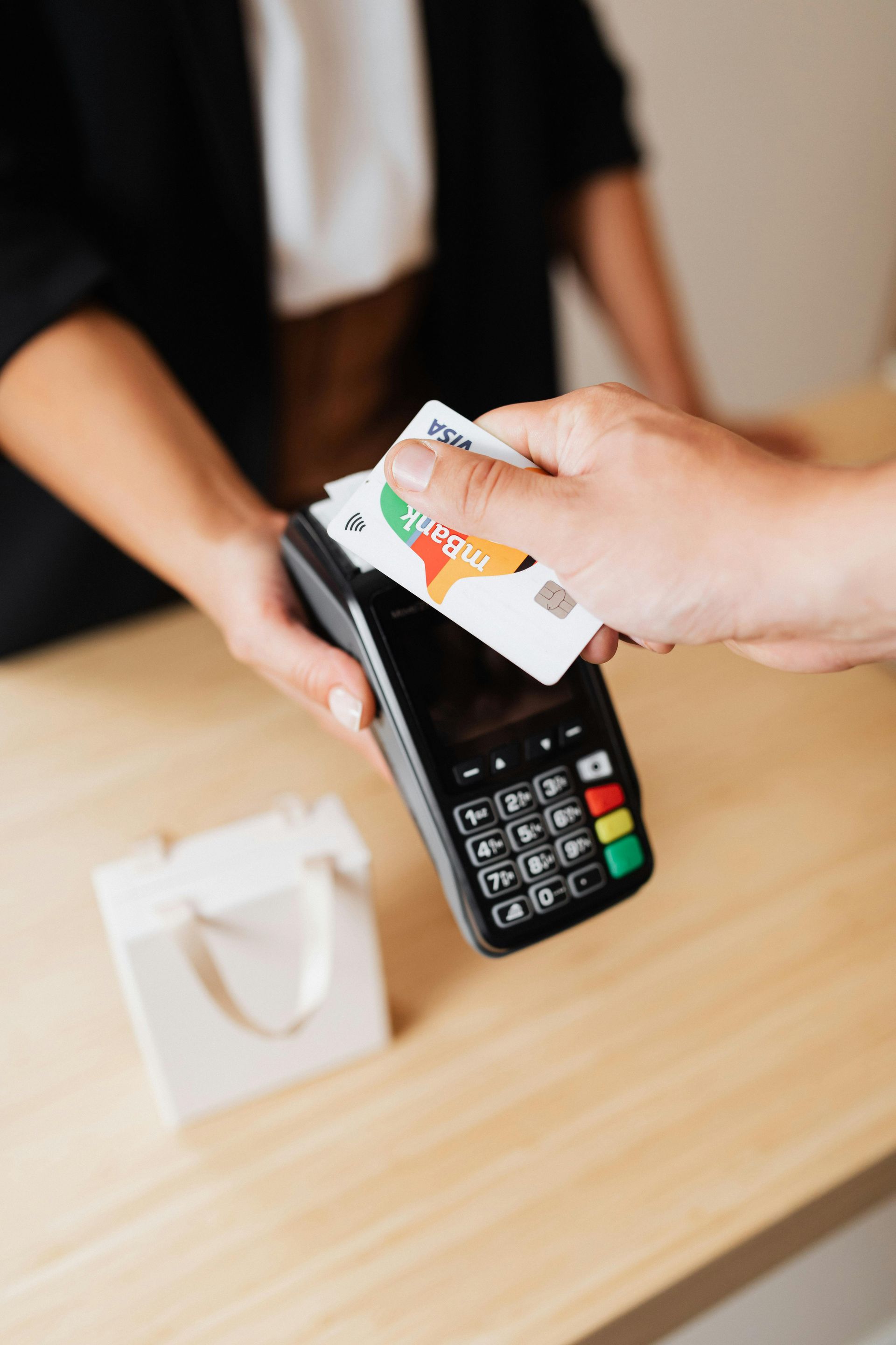 Customer hands cash to a card reader at a checkout counter