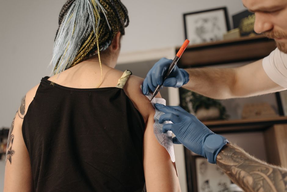 Tattooist checking the time while working on a client's tattoo session