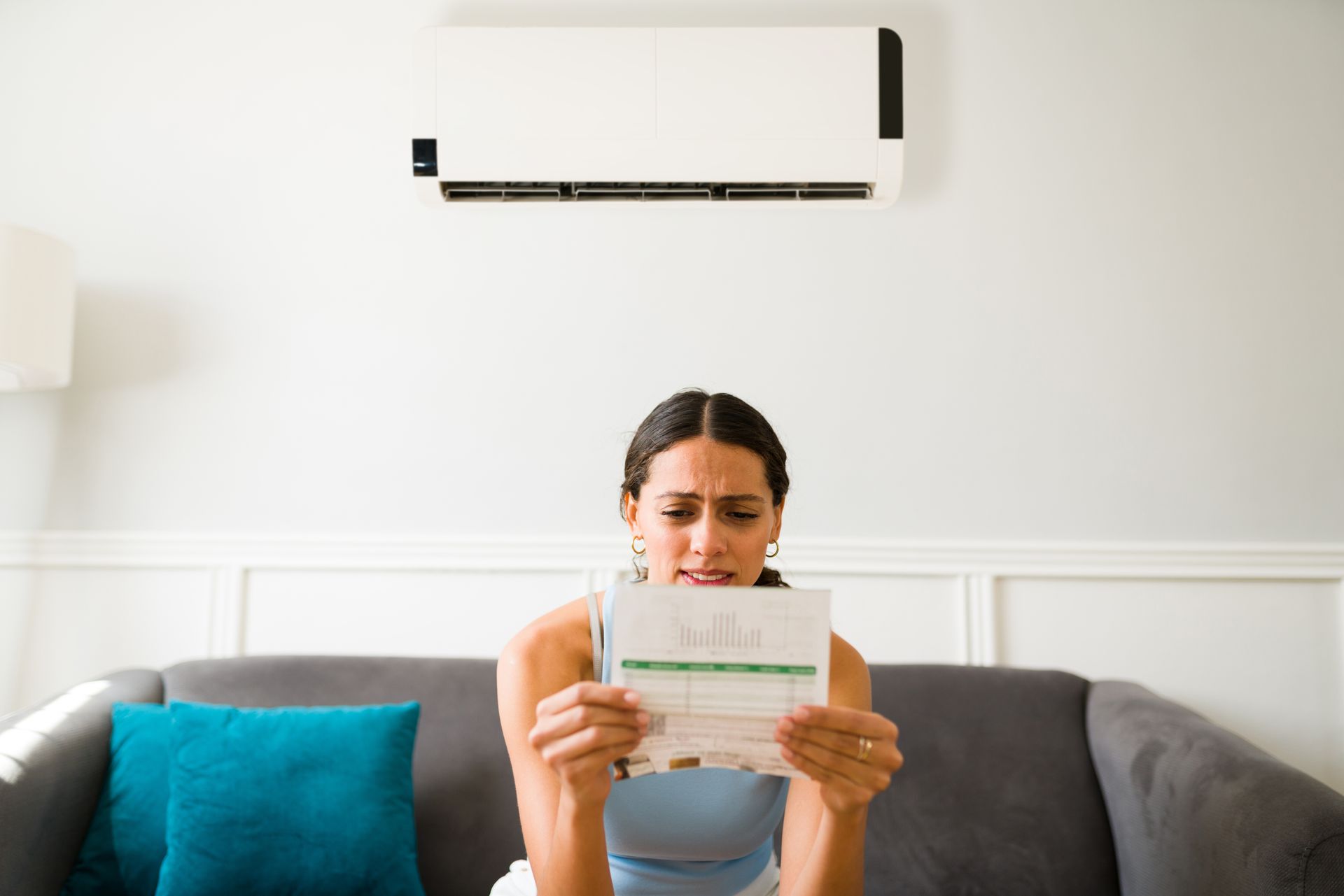 Woman sitting on a couch reading a letter in a bright living room