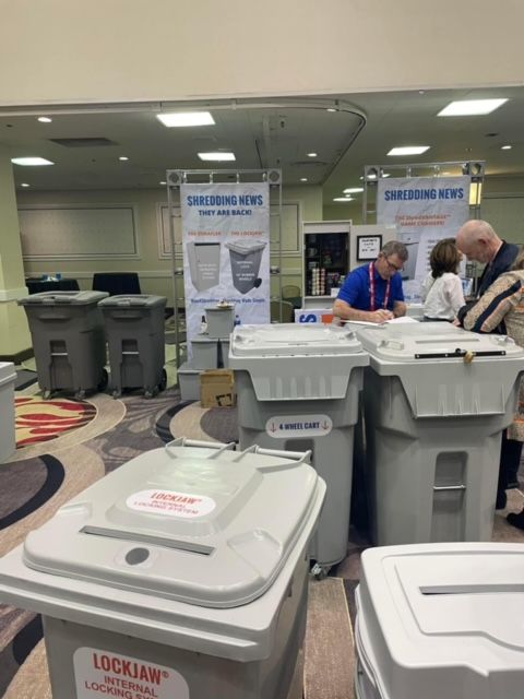 A group of trash cans are lined up in a room with a sign that says ' lockjaw ' on it