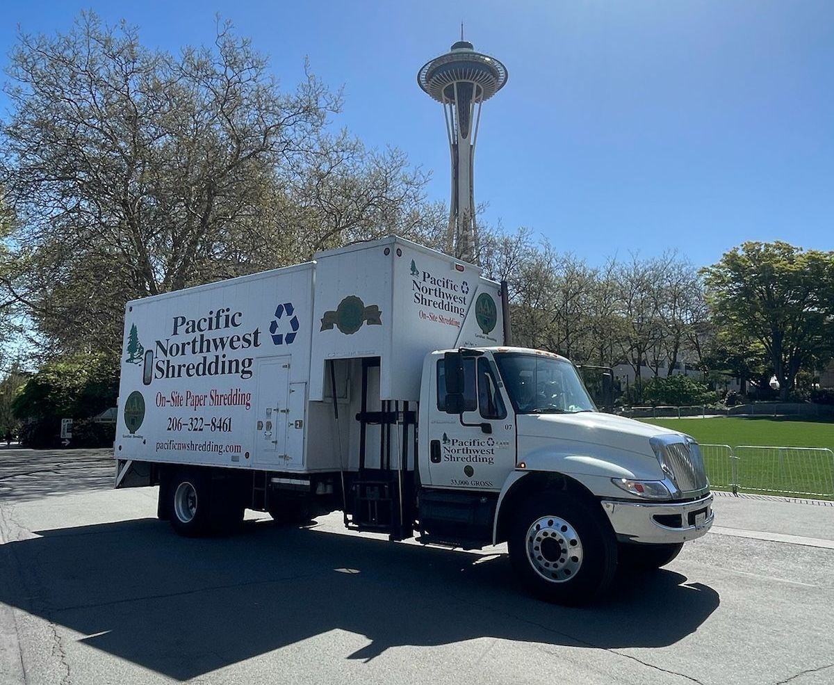 A pacific northwest shredding truck is parked in a parking lot