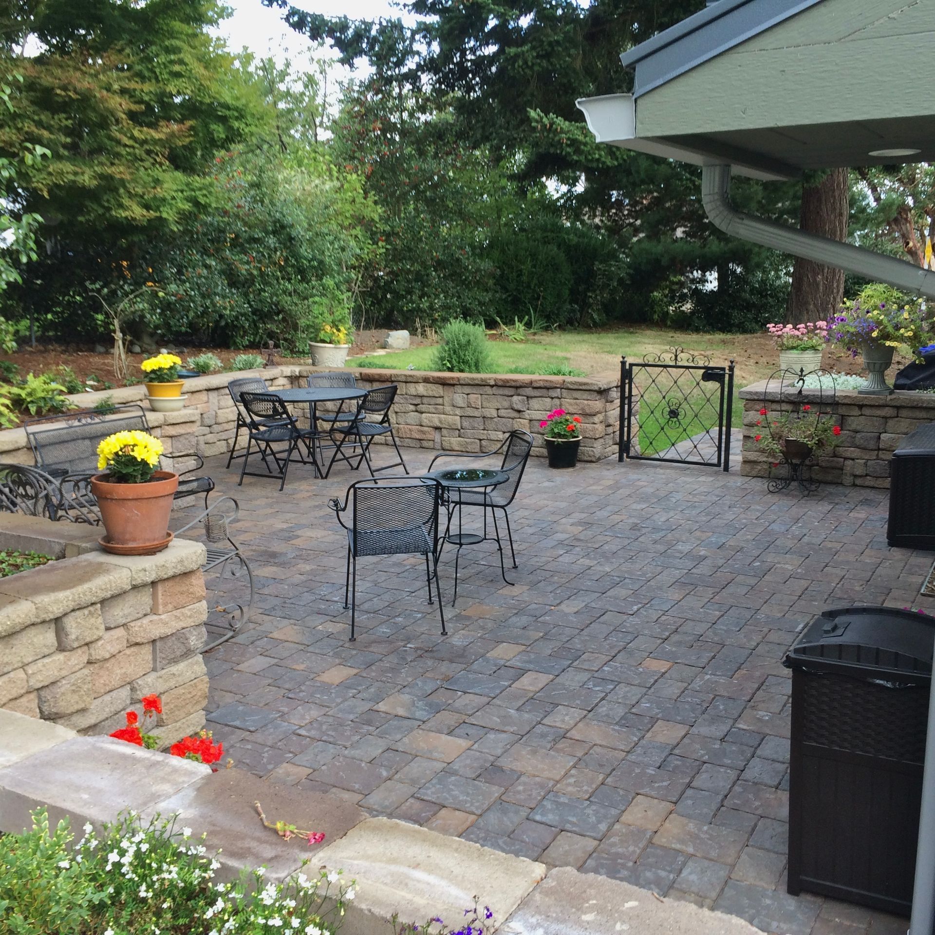 new patio with installed pavers, retaining block wall and gate